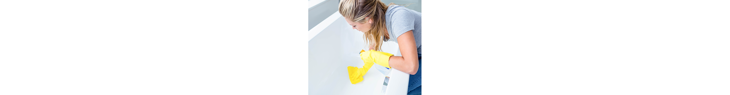 A woman wipes down a bathtub.