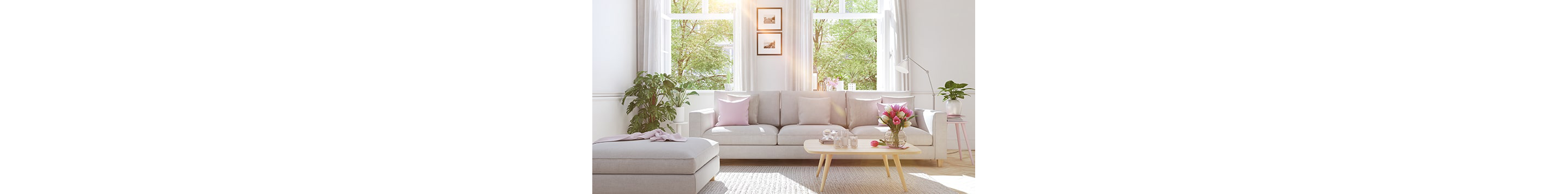 A clean living room with a couch, a footrest and a coffee table.