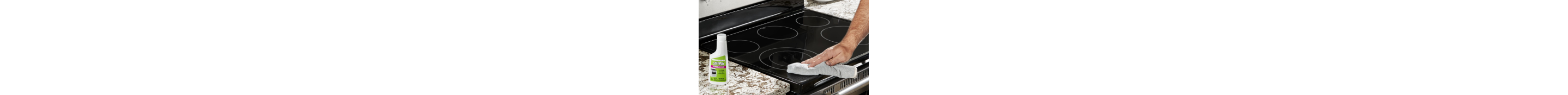 Someone cleans an induction cooktop with a cloth. On the counter is a bottle of affresh cleaner